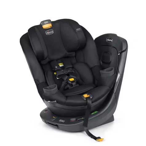 Chicco Fit360 ClearTex rotating convertible car seat in black, shown at an angle with the magnetic chest clip across the harness