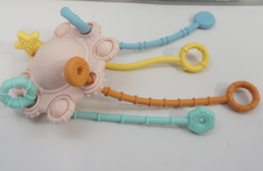 Four-string silicone teething toy. Official CPSC identification image for Pull & Chew Montessori Teething Toys.